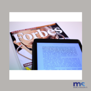 La imagen muestra una revista de Forbes y una tablet al lado de esta.