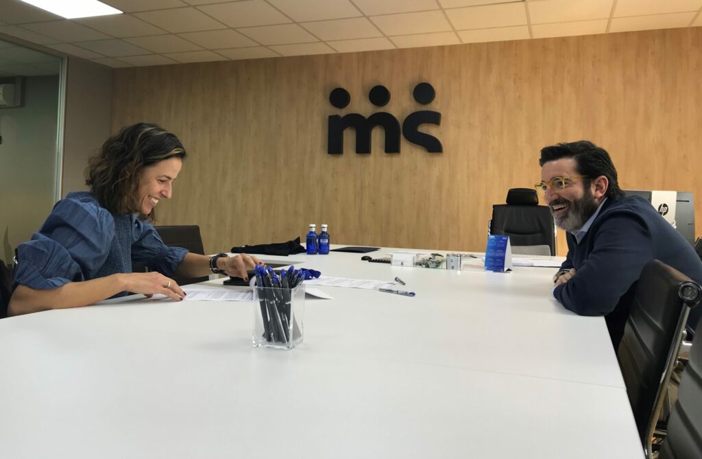 La imagen muestra como Marta Marrero firma un acuerdo con Merchanservis.