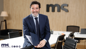 La imagen muestra a Mario del Campo, CEO de Merchanservis sentado con unos documentos de Merchanservis.
