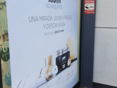 La imagen muestra un vinilo de Isidin en una tienda preparado por Merchanservis.