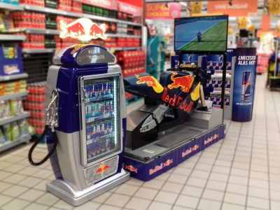 La imagen muestra un estand de Red Bull con un juego de motos con una moto como volante al lado.