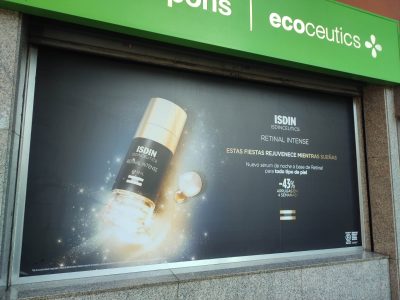 La imagen muestra un vinilo de Isidin en una tienda preparado por Merchanservis.